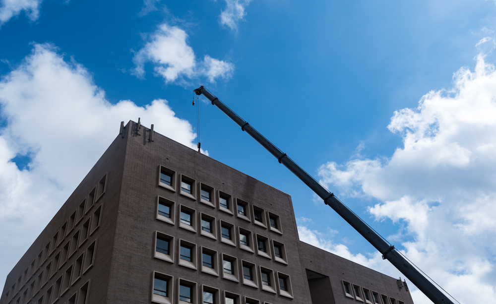 An,hvac,system,being,hoisted,onto,a,building,in,downtown,